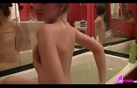 Teen plays with herself in the bathtub